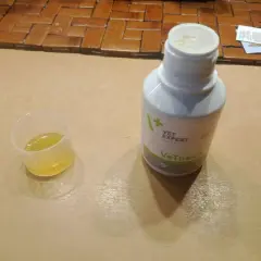 Płynna zawiesina **Vetussin** w kieliszku dozującym i butelce.